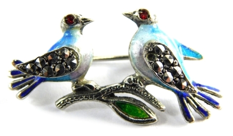 A costume jewellery bar brooch, formed as two birds, with enamel decoration, with marcasite wings and red paste stone set eyes, 3cm diameter, a plated framed. (AF)