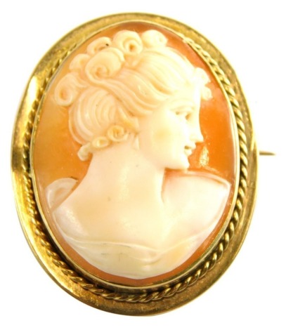 An early 20thC shell cameo brooch, depicting maiden looking right, with flowing locks, with rope twist border, yellow metal stamped 9ct, 2.5cm x 2cm, on single pin back, 7.2g all in.