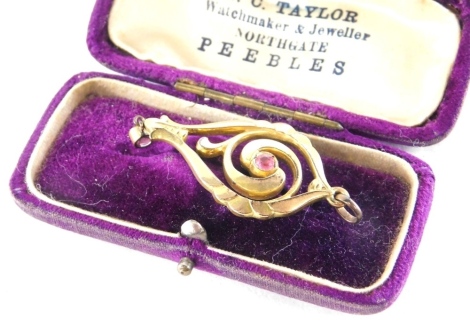 An Edwardian pendant, of scroll design set with pink topaz, in scroll design setting, plated, 4.5cm high.