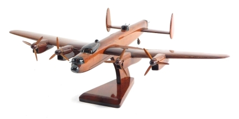 A wooden model of a Lancaster Bomber on plinth base, 14cms high.