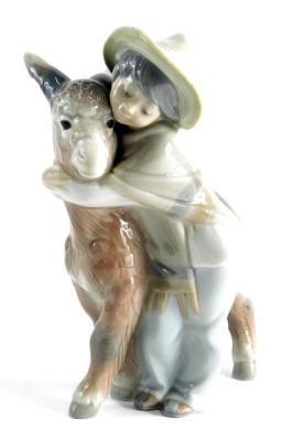 A 20thC Lladro figure group child hugging donkey, printed marks beneath, 21cm high.