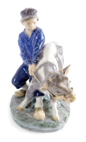 A Royal Copenhagen figure of a child and calf, number 772, marked beneath. 17cm high.