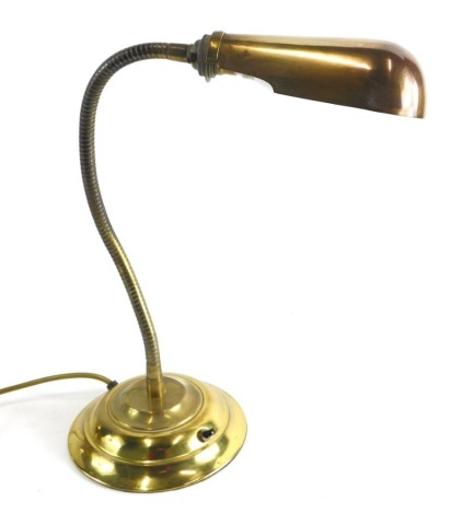 A brass adjustable lamp, with shaped shade and articulated twist stem on stepped base, the shade 17cm long.