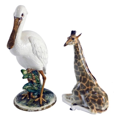 A 20thC Capodimonte pottery figure of a pelican, Majolica type, on naturalistic setting, 43cm high, labelled beneath, and a USSR figure of a seated giraffe. (2, AF)