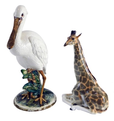 A 20thC Capodimonte pottery figure of a pelican, Majolica type, on naturalistic setting, 43cm high, labelled beneath, and a USSR figure of a seated giraffe. (2, AF)