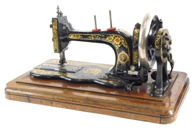 An early 20thC small Bradbury sewing machine, of small proportion, on serpentine base, in walnut case with hinged lid, 26cm high, 44cm wide, 24cm deep.