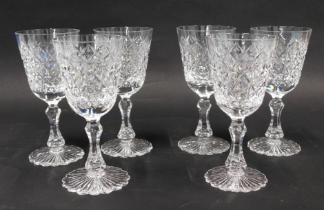 A set of six heavy crystal wine glasses, with a repeat hobnail cut diamond decoration, on shaped stems and flower head feet, unmarked, 21cm high. (6)