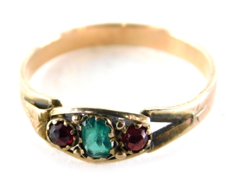 An Edwardian dress ring, set with emerald and two rubies, with V splayed shoulders, on plain design band, yellow metal unmarked, ring size O½, 1.6g all in.