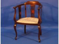 An Edwardian inlaid mahogany tub style open armchair on cabriole legs with