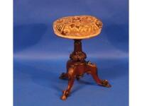 A Victorian walnut adjustable piano stool with carved decoration to the tripod base