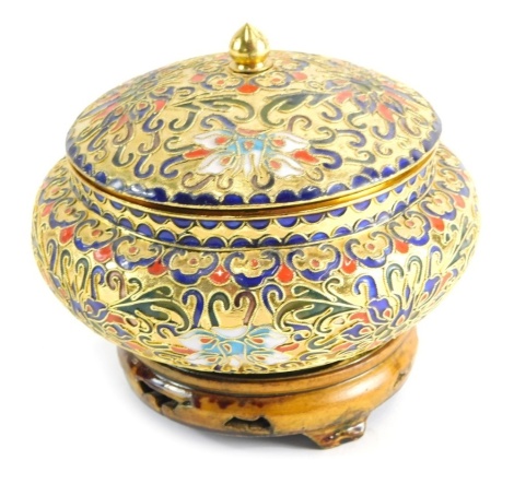 A highly decorative cloisonne jar and cover, of squat bellied form, profusely decorated with flowers on a gilt ground, on wooden plinth base, unmarked, 10cm high.