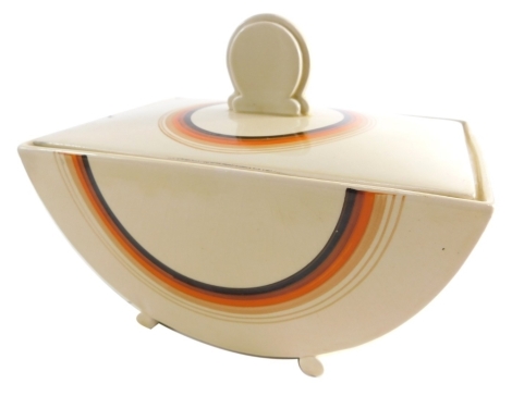 A 1930's Clarice Cliff Bizarre Biarritz jar and cover, with a line decoration printed predominately in orange, cream and brown, printed marks beneath, 15cm high.