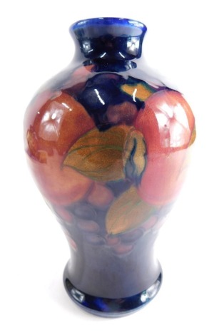 A 20thC Moorcroft pottery Pomegranate pattern vase, on blue ground impressed marks beneath 14cm high.