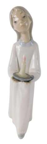 A Lladro pottery figure of a girl holding candle, printed marks beneath, 22cm high.