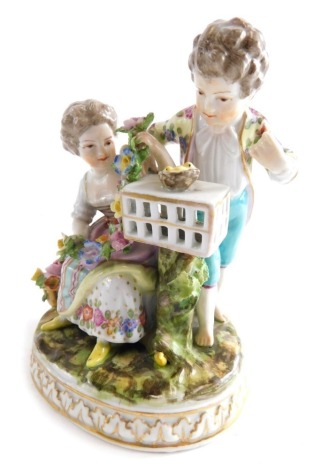 A 19thC Dresden porcelain figure group of children, with boy overlooking birds nest with girl holding garland, polychrome decorated on gilt highlighted ground, blue D R mark beneath with paper label, 15cm high.