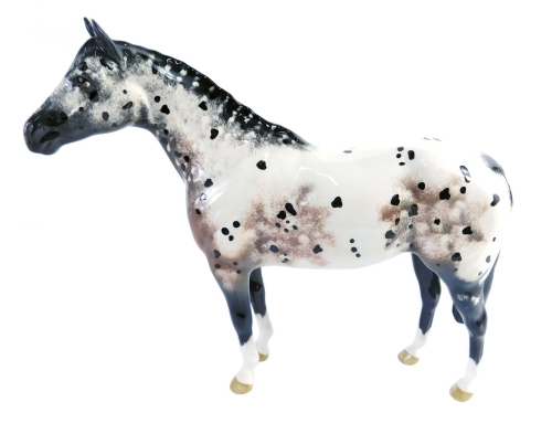 A Beswick pottery figure of a horse, Appaloosa printed marks beneath, 19cm high (AF)