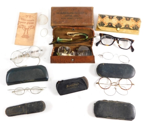 Various optical items and spectacles, spectacles cases, a pair of gilt and tortoise shell finish spectacles, 12cm wide, with curved side bars, etc. (a quantity)