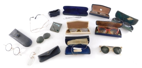 Various optical items and spectacles, a shagreen curved case, 13cm wide, containing a pair of metal rimmed spectacles with curved side bars, eye protectors with tinted glass shades, various other spectacles, etc. (a quantity)