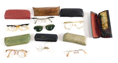 Various optical items spectacles and cases, a pair of gilt rimmed spectacles with plain side bars, in brown leather case, 16cm wide, a Mucklow stamped spectacles case, papier mache case, various other gilt coloured spectacles, a case with crows foot emble