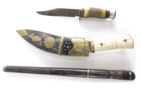 A cow horn handled kukri, with shaped scabbard with metal embellishment compressed handle and shaped blade 33cm long, an early 20thC dagger and sheath and a further dagger with horn handle and compressed metal pommel (3).