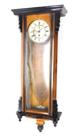 A late 19thC walnut and ebonised Vienna wall clock, the 19cm diameter fancy Roman numeric dial with subsidiary Arabic second hand, in a three part glazed case, with pendulum, single weight, and key, 92cm high.