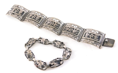 An American inspired bracelet, of six panel design, depicting warriors and birds, a vine design bracelet, each white metal stamped silver, 49g. (2)