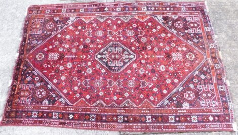 A Quashqai rug, of rectangular form with a geometrical pattern floral pattern, the inner field with flowers and squares predominately in red and blue 265cm x 170cm.