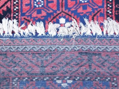 A 20thC middle eastern carpet runner, of rectangular form the outer field in a floral geometric pattern in black and red with inner decoration in cream blue and red 213cm x 102cm. - 3