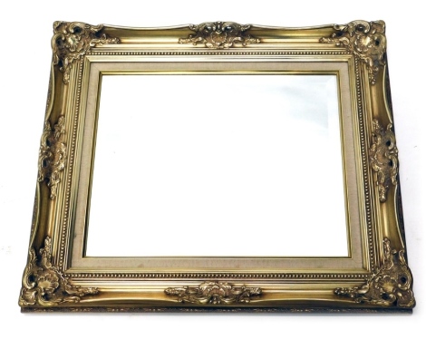 A gilt framed mirror, with scrolls and bead lining, and bevel glass, 64cm x 78cm.