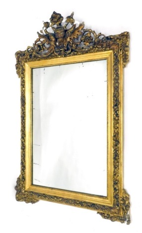 A 19thC giltwood mirror, surmounted by an urn and scroll moulding, with plain glass surrounded by further leaf and berry moulding, 127cm x 81cm.