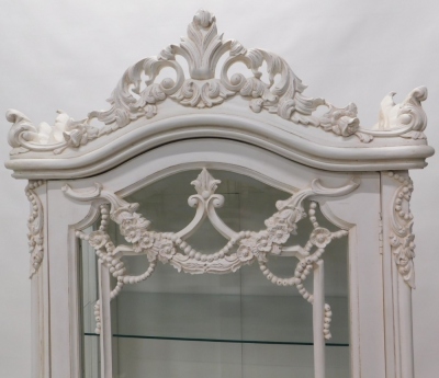 A French style painted cabinet, the arched glass door revealing three shelves surmounted by a scroll and floral moulding, on cabriole legs, 100cm high, 82cm wide, 51cm deep. - 2