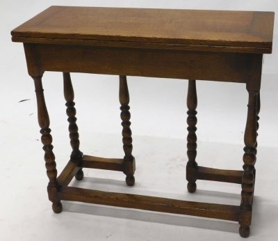 A 20thC oak fold over desk, with a brown leather tooled section with another section for ink bottles and pens, on baluster turned legs, joined by block stretchers with a side draw, when closed 77cm high, 86cm wide, 33cm deep. - 3