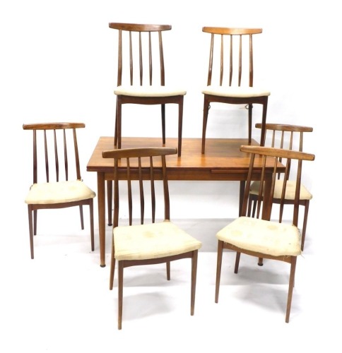 A teak G-Plan style extending dining room table and six chairs, overstuffed in cream material, the table when closed 77cm high, 130cm wide, 78cm deep. The upholstery in this lot does not comply with the 1988 (Fire & Fire Furnishing) Regulations, unless s