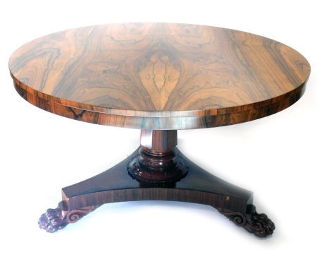 A William IV rosewood tilt top dining table, the circular top on a heavy stem, terminating in platform base and hairy paw feet, 72cm high, 128cm diameter.