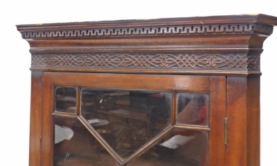 A mahogany freestanding corner cabinet, the dentil top with a blind fret, above an astragal glazed door and single cupboard, on bracket feet, 183cm high, 66cm wide, 50cm deep. - 2