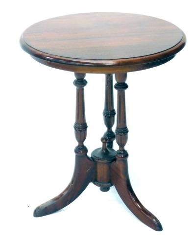 A mahogany occasional table, the circular top on triple turned supports terminating in sabre legs, 60cm high, 52cm diameter.