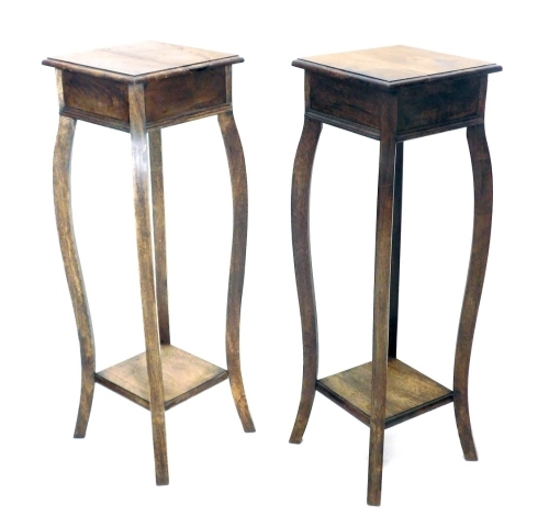 A pair of early 20thC torcheres, each with square tops on serpentine legs with shelf beneath, 91cm high. (2)