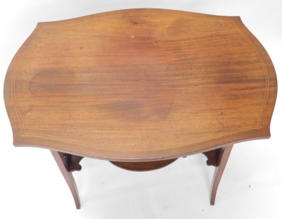 An Edwardian mahogany occasional table, the shaped top with a double line inlay, above lyre supports, joined by an oval under tier, on sabre legs, 71cm high, 80cm wide, 48cm deep. - 2