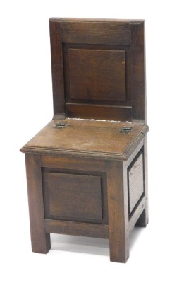 A child's oak chair, with hinged lid, panelled back and sides, on stiles, 72cm high.