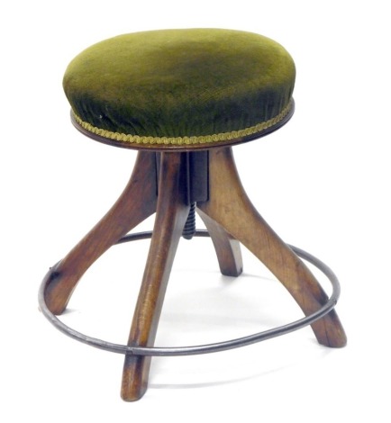 An oak framed stool, with metal hoop foot supports, overstuffed in green material, 44cm high, the top 36cm diameter.