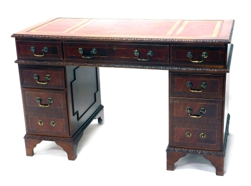 A 20thC mahogany pedestal desk, with three part tooled red leather top, raised above three frieze drawers and six pedestal drawers, locks stamped SC&S, 77cm high.