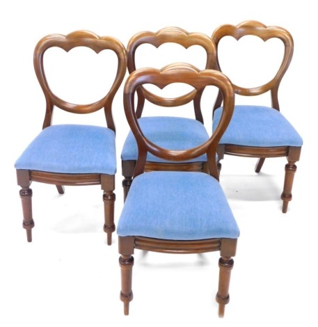A set of four Victorian mahogany balloon back dining chairs, each in later overstuffed blue material, on turned front and sabre back legs, 88cm high. (4)