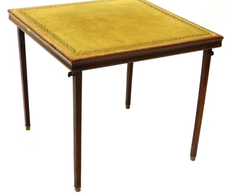 An oak card table, the baize top with a floral garland decoration, on square tapering legs terminating in brass caps, 72cm high, 79cm wide, 77cm deep.