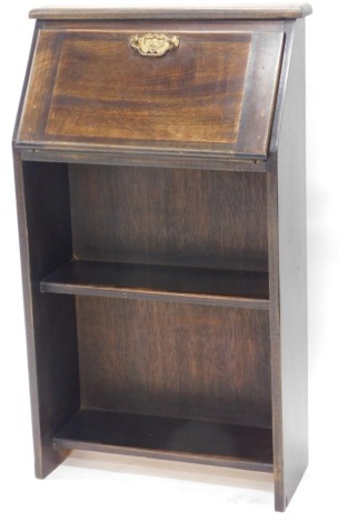 An early 20thC bureau, of small proportion, with open bookcase, the fall revealing a fitted interior, on stiles, 100cm high, 61cm wide, 21cm deep.