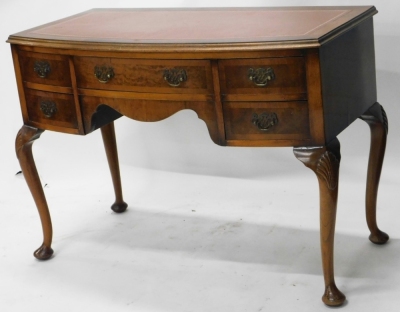 A 20thC walnut writing desk, with later tooled leather top, above central drawer flanked by four further drawers, on cabriole legs terminating in pad feet, 78cm high, 103cm wide, 51cm deep.