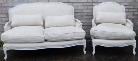 A two piece French salon suite, in cream, the settee with very deep seat, and overstuffed back, with additional cushions, on cabriole legs, matching armchair, 85cm high, 48cm wide, 75cm deep.