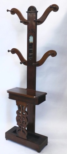 A Victorian mahogany tree shaped hall stand, with S scroll hangers, oblong mirror, and glove box, with a heavily carved pierced front, with lead lined section beneath, on bun feet, 201cm high, 62cm wide, 31cm deep.