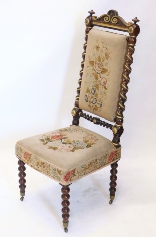 A 19thC rosewood and gilt highlighted prie dieu chair, heavily carved with a scroll back, turned supports, and overstuffed to the back and seat in petit point floral material, on turned legs terminating in castors, 119cm high.