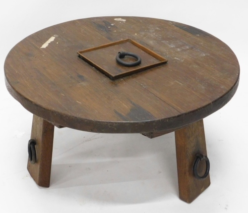 A Continental heavy oak coffee table, the circular top on shaped stiles, with metal ring additions, 42cm high, 77cm diameters.