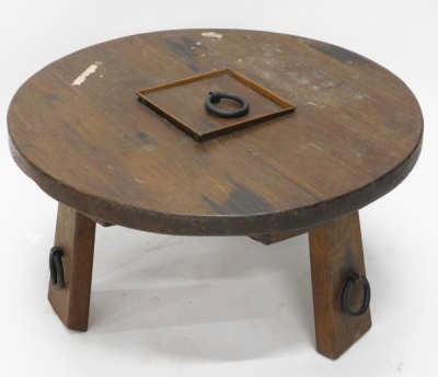 A Continental heavy oak coffee table, the circular top on shaped stiles, with metal ring additions, 42cm high, 77cm diameters.